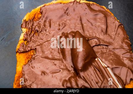 Spreading chocolate cream on toasted bread Stock Photo