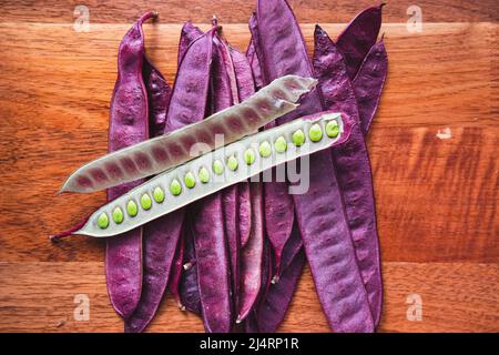 Pile of Guaje seed pods on a wood table with one open seed pod in Oaxaca, Mexico Stock Photo