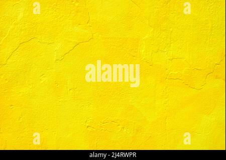 detail of an irregular stucco wall painted yellow or orange Stock Photo
