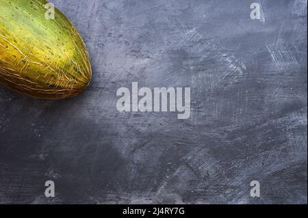 detail of an unbroken melon on a dark background Stock Photo