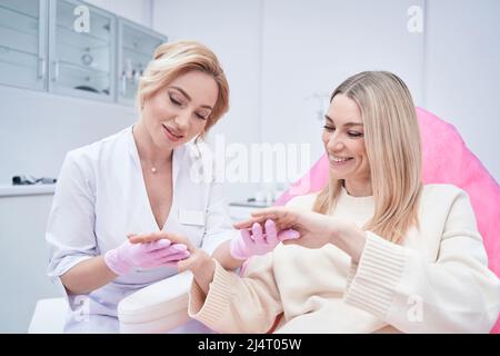 Focused Caucasian dermatologist performing skin examination procedure Stock Photo