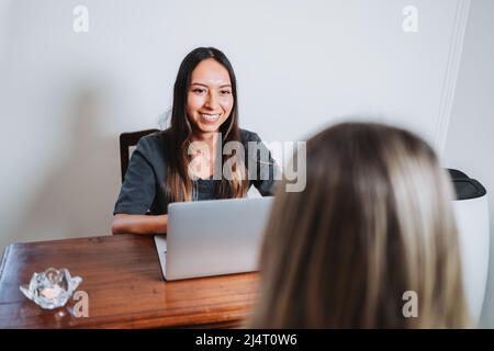Young latin therapist taking data from an unrecognizable patient before a medical meeting. Healthcare consulting. Stock Photo