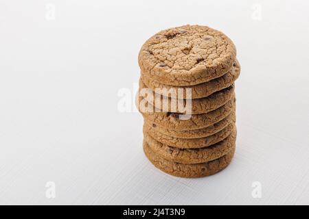 vertical stack of round chip cake cookies with chocolate on white surface background Stock Photo