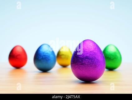 Chocolate easter eggs with shiny Red, yellow, purple, blue and green foil on white background. Close-up. Stock Photo