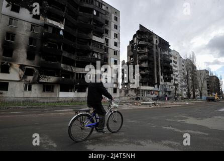 April 17, 2022, Borodianka, Ukraine: A man rides a bicycle past a destroyed residential area that was damaged as a result of the shelling of the Russian army in the city of Borodianka, northwest of the Ukrainian capital Kyiv. In Borodyanka in the Kiev region, rescuers pulled out the bodies of 41 dead from under the rubble. This was reported by the press center of the State Service of Ukraine for Emergency Situations. Russia invaded Ukraine on 24 February 2022, triggering the largest military attack in Europe since World War II. (Credit Image: © Sergei Chuzavkov/SOPA Images via ZUMA Press Wire) Stock Photo