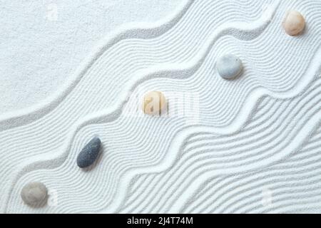 Zen garden with peble stones on white sand pattern Stock Photo