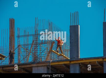 A worker prepares formwork for a modern metal-concrete structure of a residential building. Stock Photo