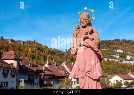 Saint Ursanne, Switzerland - October 19, 2021: Statue of St. John Nepomuk on the bridge over the Doubs River in Saint Ursanne Stock Photo