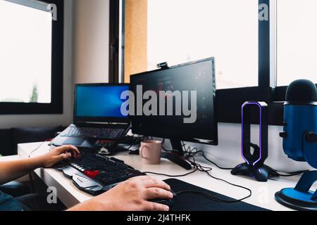 hands of a young man working as a programmer from home on his computer. Stock Photo