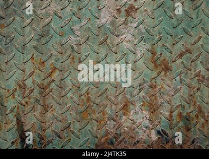 Close up of dirty green and rusted metal sheet with repeated pattern imprinted Stock Photo