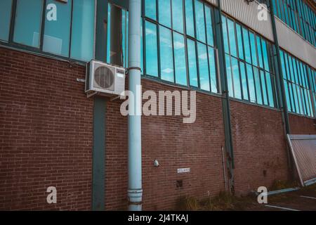 Factory facade reflecting the sky in its windows Stock Photo