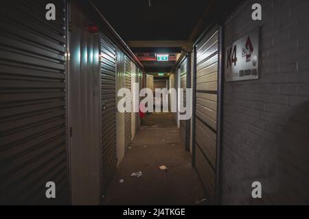 Long dark corridor with doors to storage in a warehouse Stock Photo