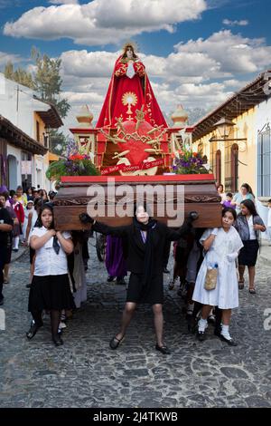 Antigua, Guatemala.  Semana Santa (Holy Week).  Young Girls Carrying an Anda (Float) of the Virgin Mary in a Religious Procession. Stock Photo