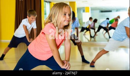 Portrait of smiling children practicing sport dance in modern dance hall Stock Photo