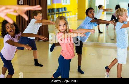 Portrait of smiling children practicing sport dance in modern dance hall Stock Photo