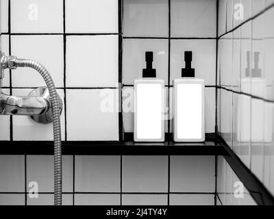 White blank labels mockup on two shower bottles, pump bottle with dispenser for liquid soap, shampoo, shower gel, side view. Close-up empty package la Stock Photo