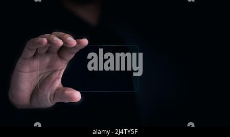 Future transparent glass phone Technology. Mock-up blank screen futuristic transparent smartphone in human hand on dark with copy space, horizontal. F Stock Photo