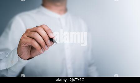Black pen in businessman's hand while drawing with empty on white background with copy space. A man, a person writes something on a virtual screen. Stock Photo