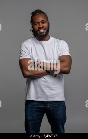 Cheerful guy posing for the camera against the gray background Stock Photo