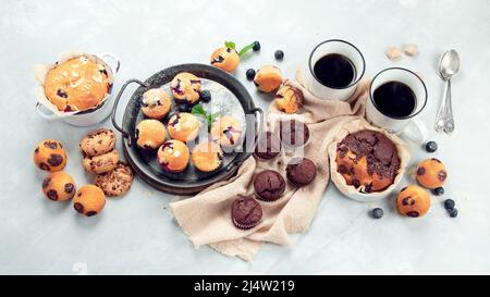 Muffins assortment on light background. Freshly baked cupcakes. Celebration concept. Top view, flat lay Stock Photo