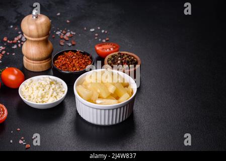 Canned pineapple chunks. Pineapple pieces on dark background Stock Photo