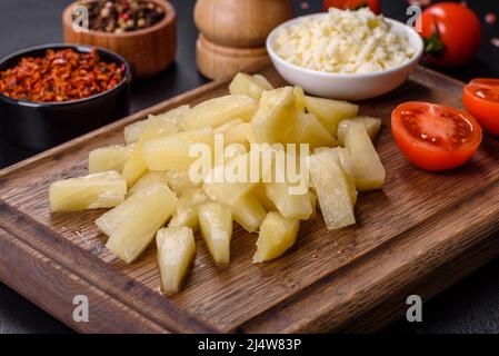 Canned pineapple chunks. Pineapple pieces on dark background Stock Photo