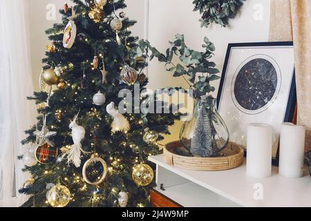 Christmas composition with decoration, christmas tree, gifts, snow and accessories in cozy home decor. Copy space. White and gold Stock Photo