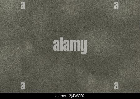 Background of dark gray suede matte fabric closeup. Velvet matt texture of black nubuck textile. Velveteen pattern. Stock Photo