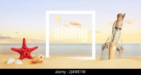 White square paper frame on beach sand surrounded by sea star, shells and message in the bottle. Copy space in the middle Stock Photo