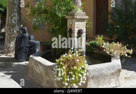 Placette with flowery fountain in Grimaud Stock Photo