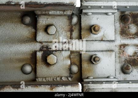 the junction of steel plates with rivets and hexagonal screws at an old bridge Stock Photo