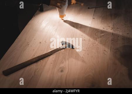 An old hammer with a long handle. Small working tools of a carpenter on a dusty table. Stock Photo