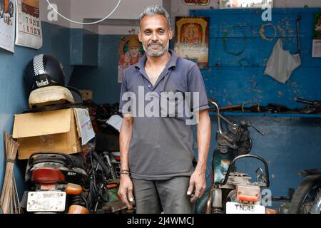 Motorcycle mechanic posing in his workshop inTrichy, Tamil Nadu, India Stock Photo