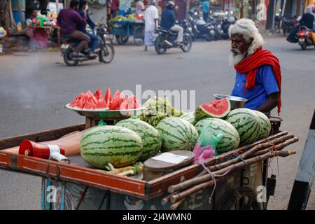 Old whitehaired man selling water melons from his cart in Trichy, Tamil Nadu, India Stock Photo