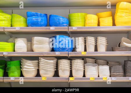 Shelves in the store with plastic storage bowls. Inexpensive alternative to subjects made from natural materials. Set of plastic baskets and boxes in Stock Photo