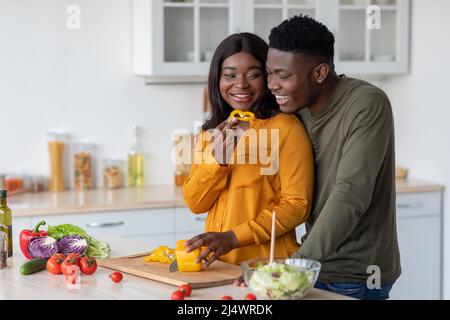 Cheerful Young Black Spouses Preparing Healthy Meal Together In Kitchen Stock Photo