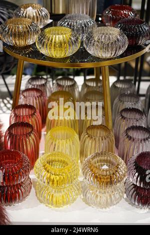 Glass colorful candelsticks with electric candels on the table Stock Photo