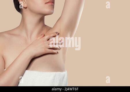 Armpit epilation, lacer hair removal. Young woman holding her arms up and showing clean underarms, depilati on smooth clear skin .Beauty portrait. Ski Stock Photo