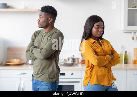 Young Black Couple Standing Back To Back To Each Other In Kitchen Stock Photo