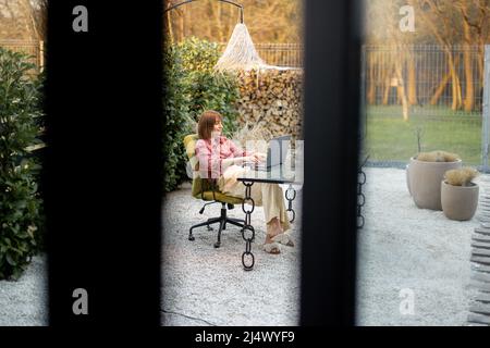 Woman works at outdoor office in the beautiful garden Stock Photo