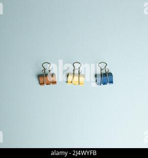 Binder clip on blue background. top view, copy space Stock Photo