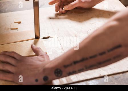 cropped view of blurred joiner cutting plank with band saw Stock Photo
