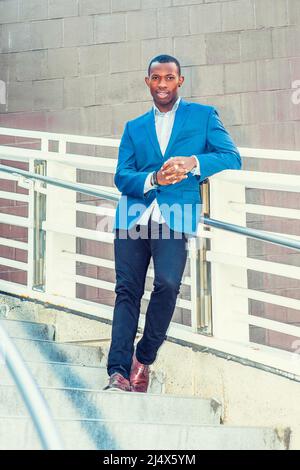 Portrait of Business Man. Wearing blue blazer black pants short haircut ear stud bracelets finger ring a young black guy standing against metal Stock Photo Alamy