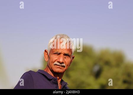 Close-up portrait Photo of an Indian farmer with blue sky background Stock Photo