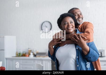 happy and senior african american man embracing smiling wife Stock Photo
