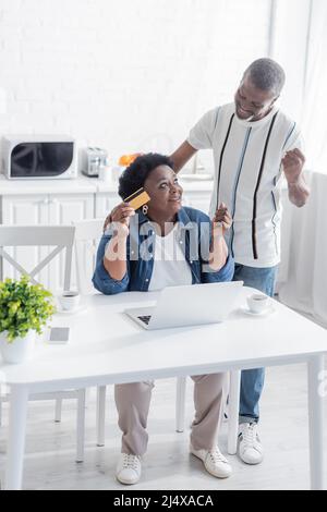 happy senior african american couple making online order while using laptop Stock Photo