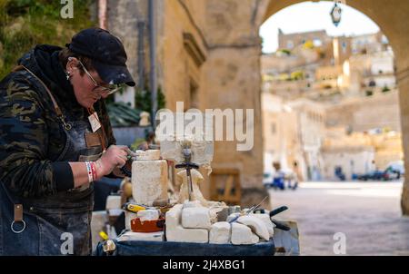 artisan woman work on stone creating a statue with her tools and materials Stock Photo