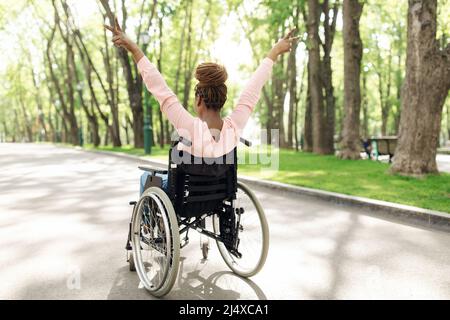 Woman in a wheelchair enjoying a walk with family Stock Photo - Alamy