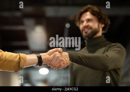 Contract conclusion and successful agreement. Happy entrepreneur shaking hands with his business partner at office Stock Photo
