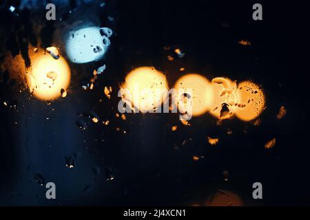 Raindrops on the glass with the bokeh of night light Stock Photo